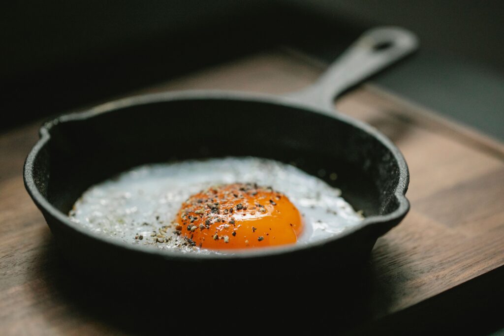 Fried egg in a skillet as a simple high protein breakfast option.
