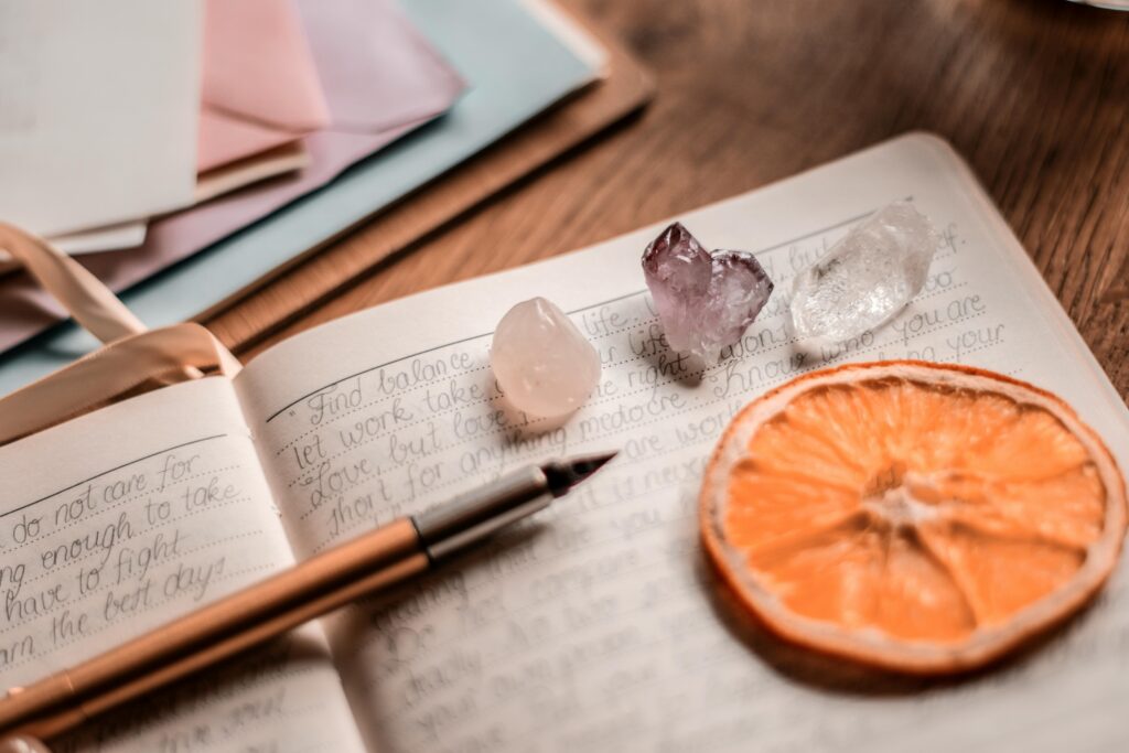 journaling notebook with handwritten reflections, crystals, and dried citrus decoration